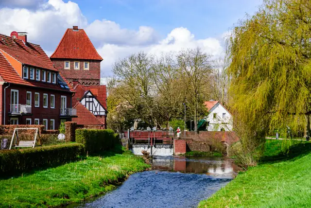 Die Berkel am Walkenbrückentor in Coesfeld mit Fachwerkhäusern, grünen Ufern und blauem Himmel